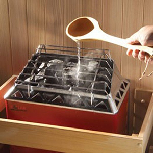 Pouring Water On An Electric Sauna